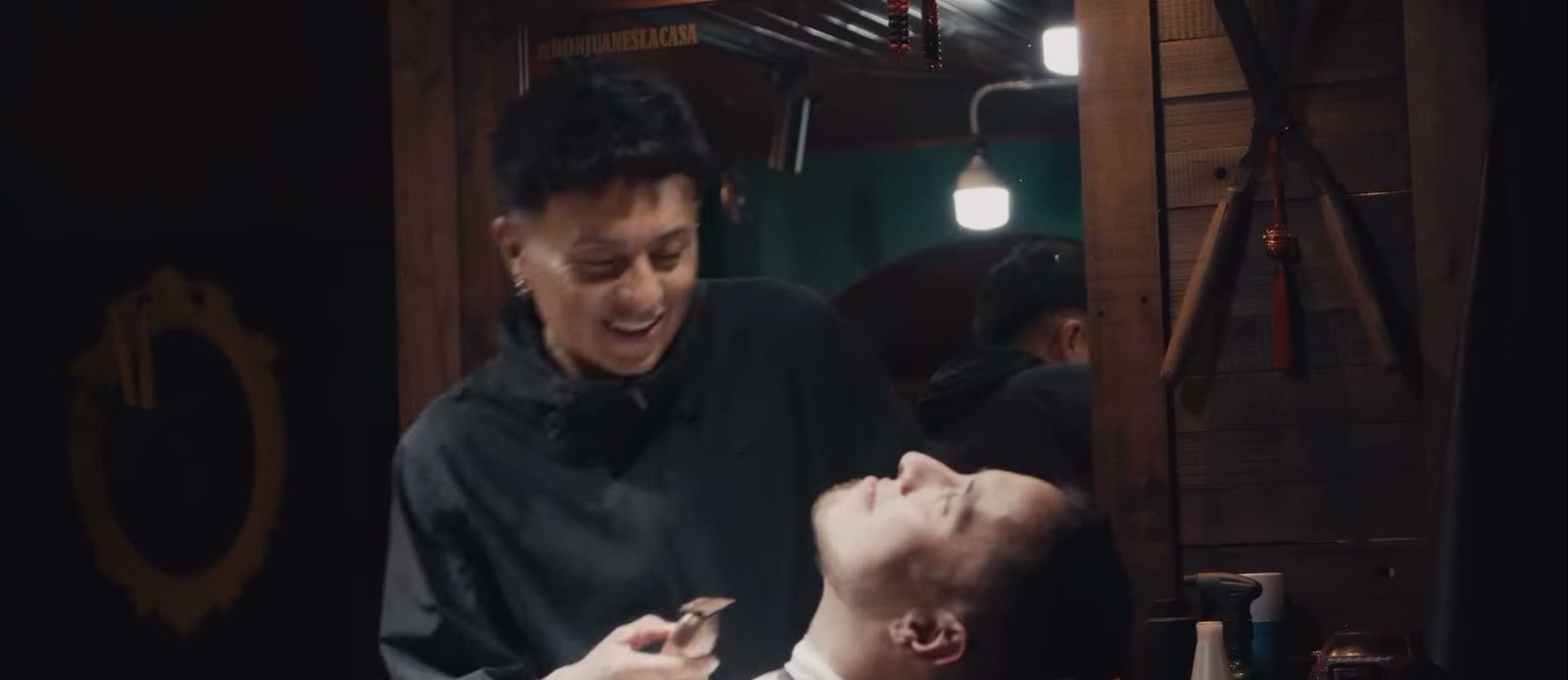 Barbero sonriendo mientras perfila a un cliente