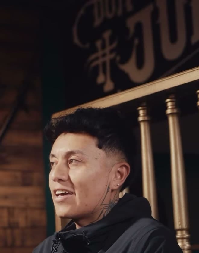 Barbero de la casa frente al letrero de madera